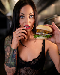 Dove in black lingerie holding a juicy hamburger